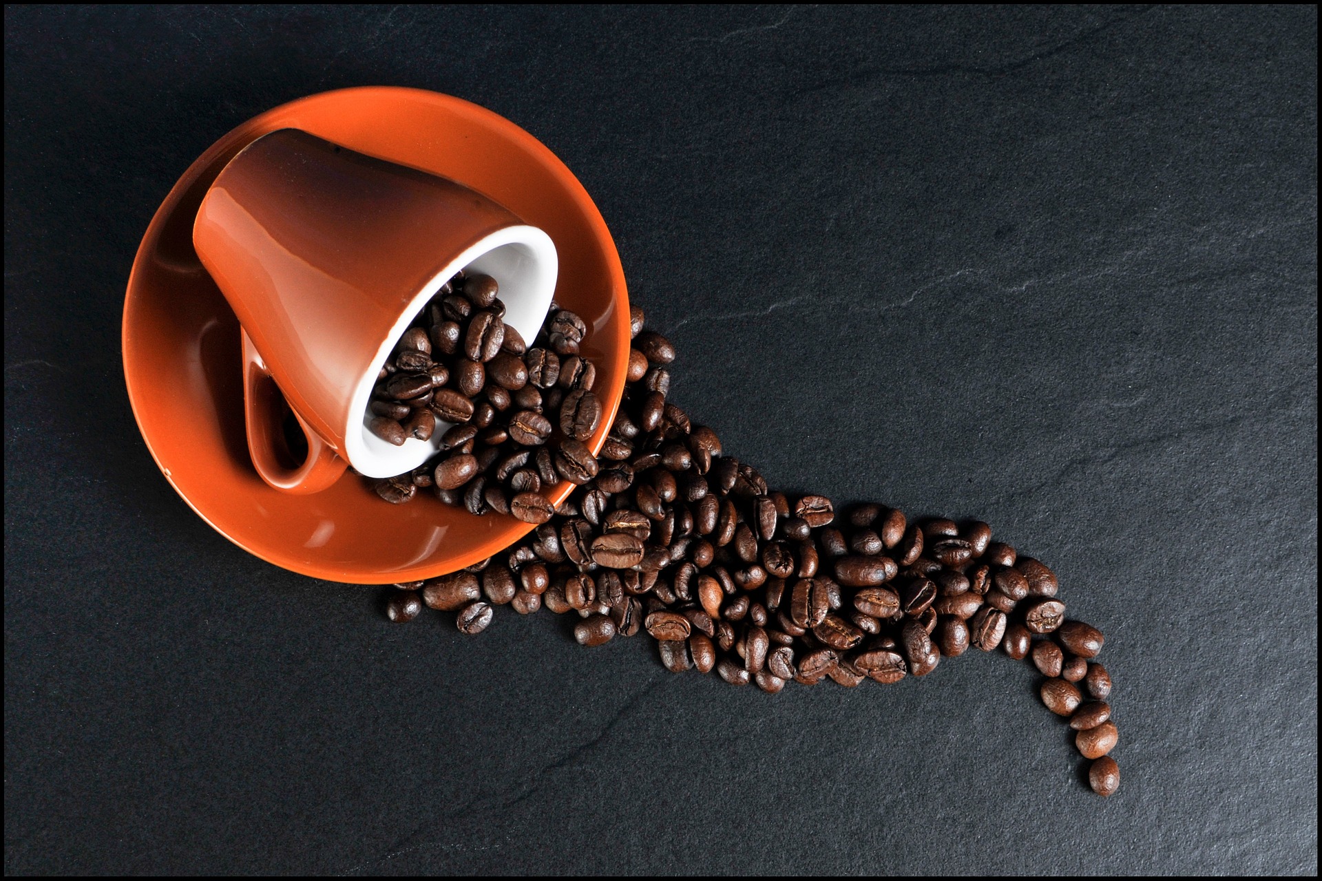 A spilled mug full of coffee beans
