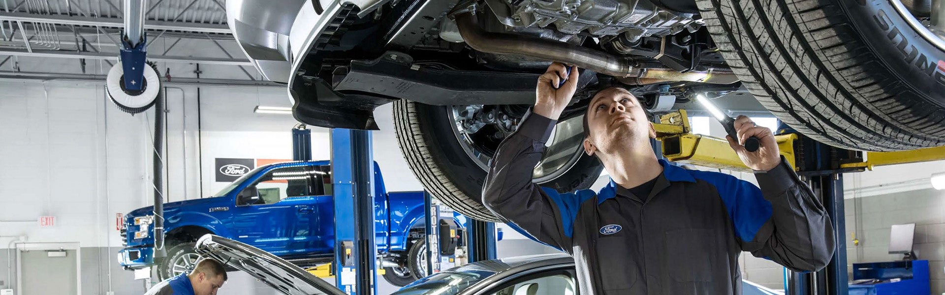 Ford technician checking beneath vehicle