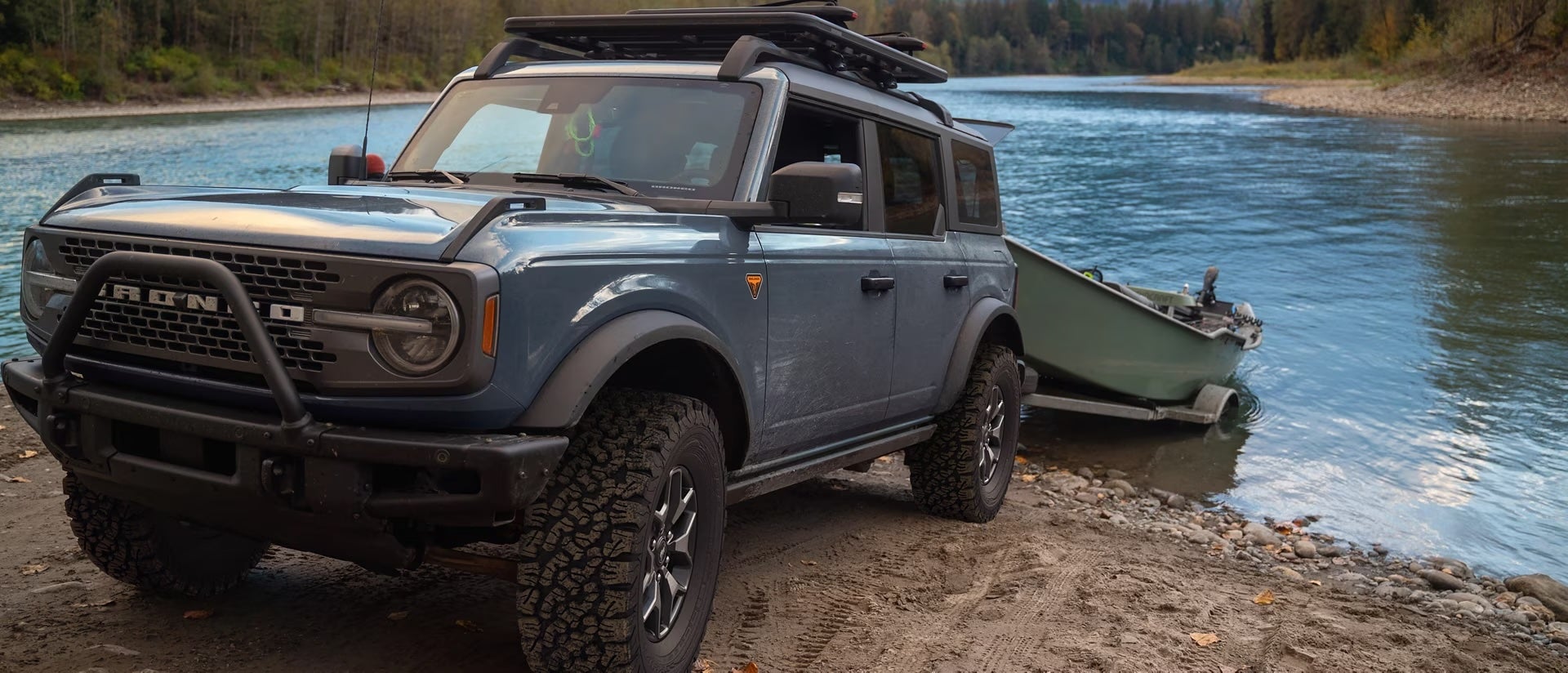 A 2025 Ford Bronco® SUV backing a trailer with a boat on it into a lake